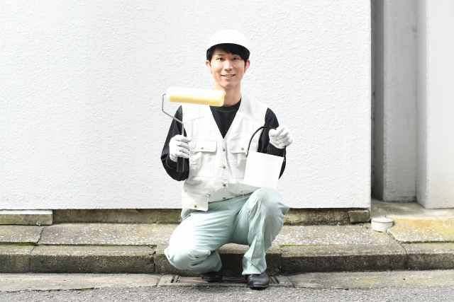 塗装ローラーを持つ男性作業員
