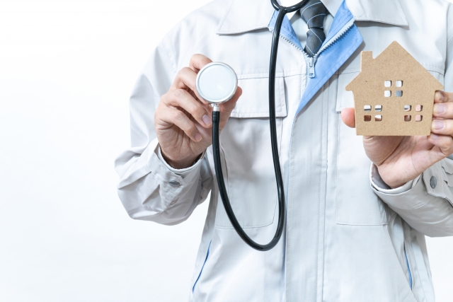 家を診断する作業着のビジネスマン